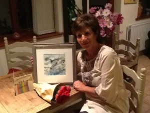 Picture of Sara holding her artwork in a photo frame