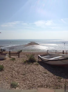 A photo of a stone beach, a small boat sits on the beach